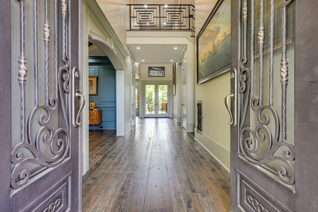 entrance foyer with a towering ceiling, french doors, dark hardwood / wood-style floors, and crown molding