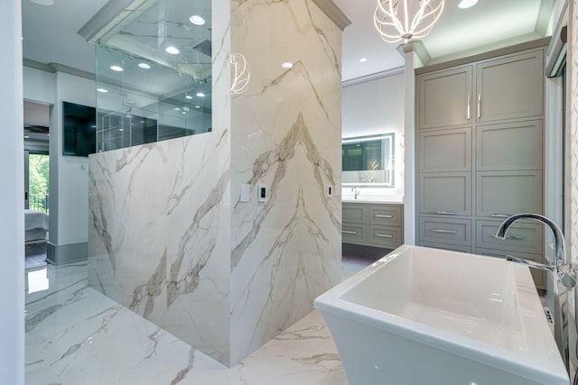 bathroom featuring tile flooring, a notable chandelier, vanity, crown molding, and a bathing tub