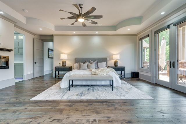 bedroom featuring dark hardwood / wood-style floors, french doors, access to exterior, ceiling fan, and a tray ceiling