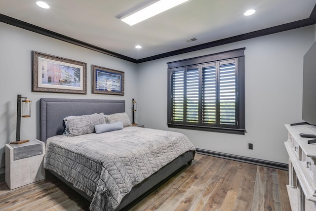 bedroom featuring light hardwood / wood-style flooring and crown molding