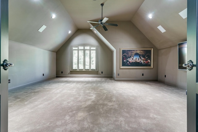 additional living space with ceiling fan, light colored carpet, and vaulted ceiling