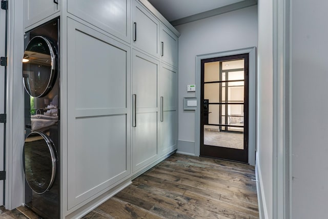 doorway to outside featuring dark hardwood / wood-style flooring and stacked washer and dryer