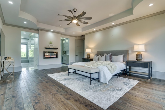 bedroom featuring a raised ceiling, ornamental molding, ceiling fan, and dark wood-type flooring