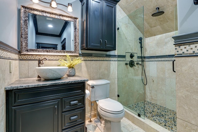 bathroom with a shower with shower door, vanity, tasteful backsplash, tile walls, and tile floors