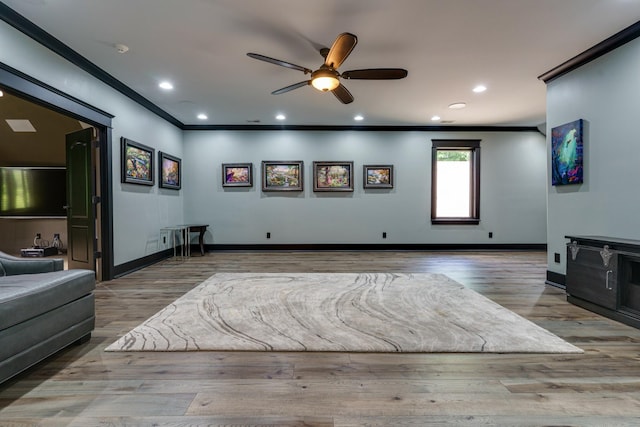 living room featuring dark wood-type flooring, crown molding, and ceiling fan