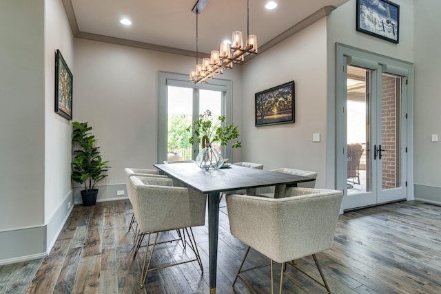 dining space featuring a chandelier, dark wood-type flooring, and ornamental molding