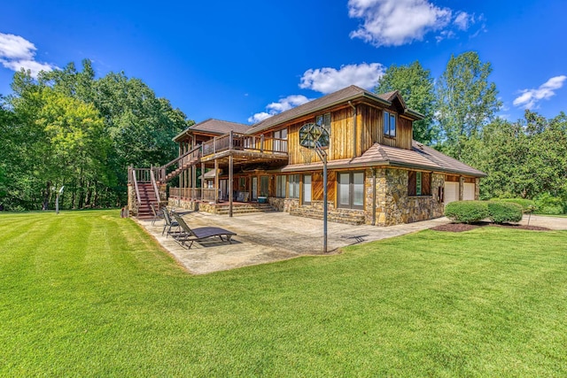 rear view of property featuring a lawn, a wooden deck, a patio, and a garage