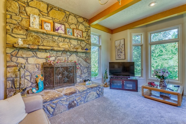 carpeted living room with a textured ceiling, beam ceiling, and a fireplace