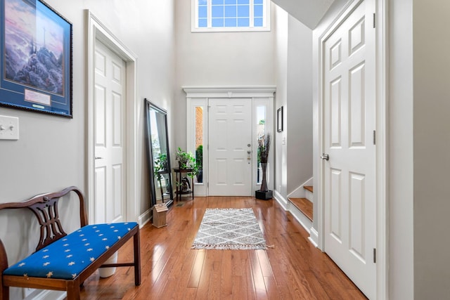 foyer entrance featuring a high ceiling and light hardwood / wood-style flooring