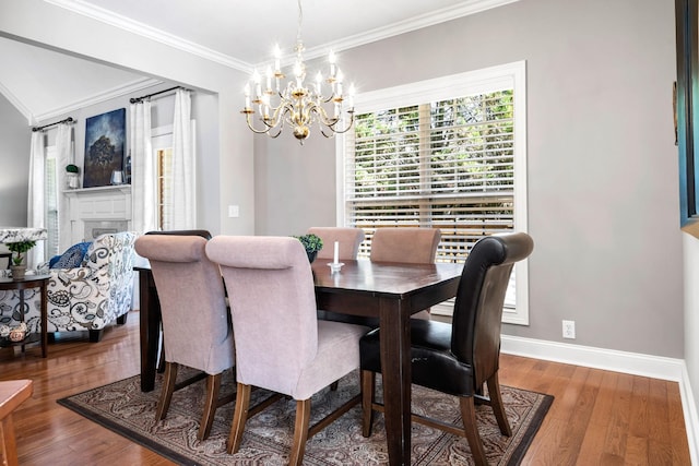 dining space with a chandelier, ornamental molding, and dark wood-type flooring