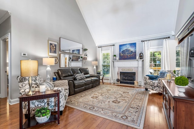 living room featuring plenty of natural light, crown molding, a fireplace, and dark hardwood / wood-style floors