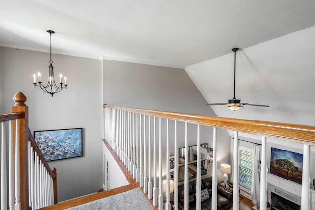 stairs featuring crown molding, carpet floors, ceiling fan with notable chandelier, and lofted ceiling