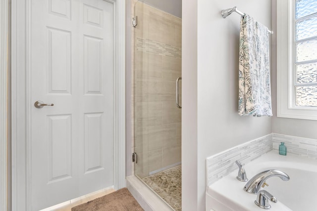 bathroom featuring shower with separate bathtub and plenty of natural light