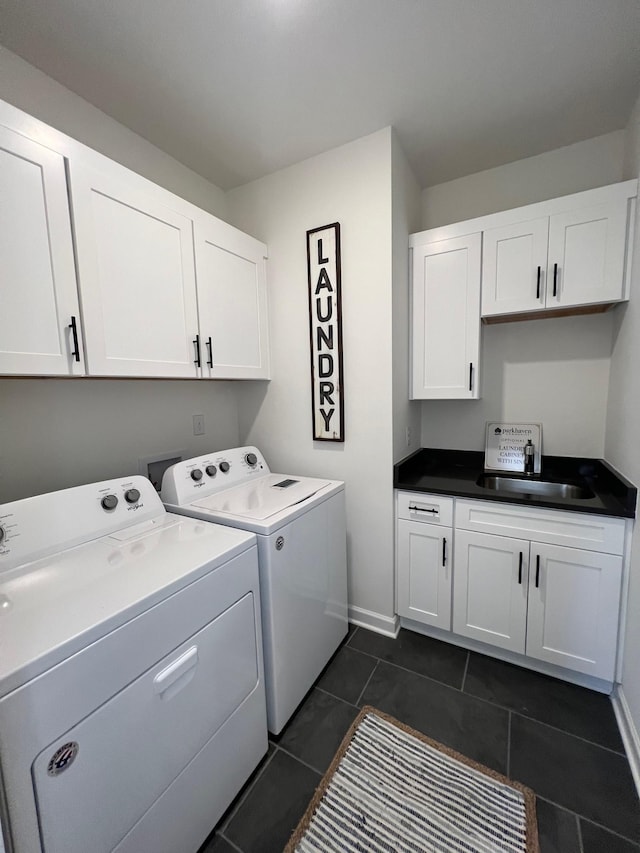 clothes washing area featuring washer and dryer, dark tile patterned flooring, sink, and cabinets