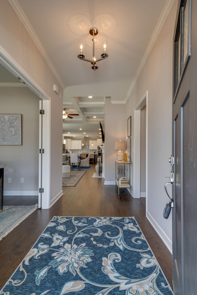 foyer entrance with ceiling fan with notable chandelier, hardwood / wood-style floors, ornamental molding, and coffered ceiling