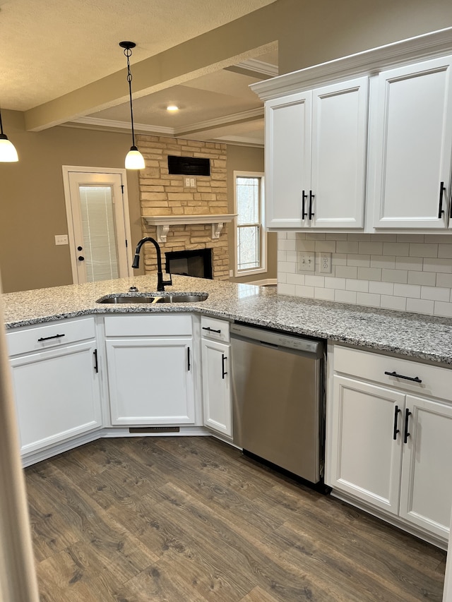 kitchen with stainless steel dishwasher, dark wood-type flooring, sink, and pendant lighting