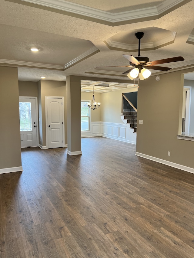 spare room featuring dark hardwood / wood-style flooring, a wealth of natural light, ornamental molding, and ceiling fan with notable chandelier