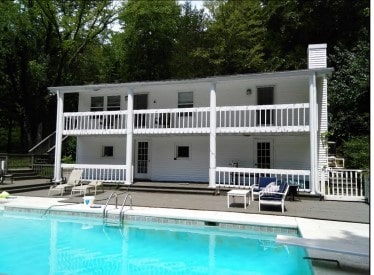 back of property with a balcony and a patio