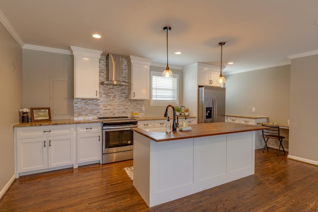 kitchen with pendant lighting, dark wood-type flooring, appliances with stainless steel finishes, wall chimney exhaust hood, and white cabinetry