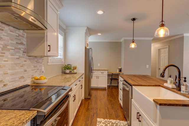 kitchen with butcher block countertops, ventilation hood, backsplash, and stainless steel appliances