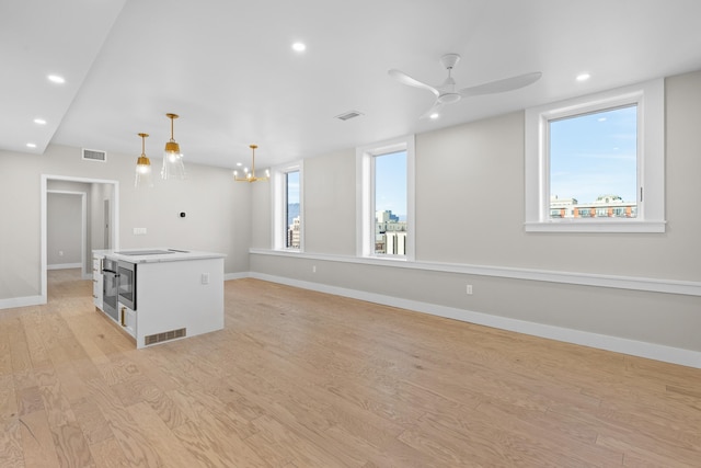 interior space featuring pendant lighting, a center island, light hardwood / wood-style floors, and a healthy amount of sunlight