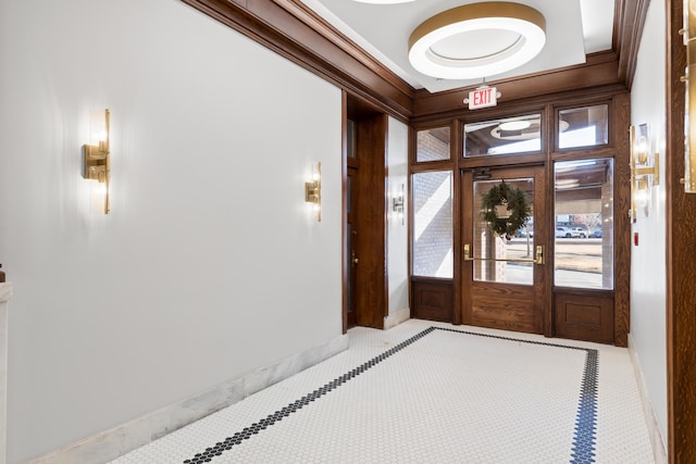 foyer entrance with crown molding, tile patterned flooring, and french doors