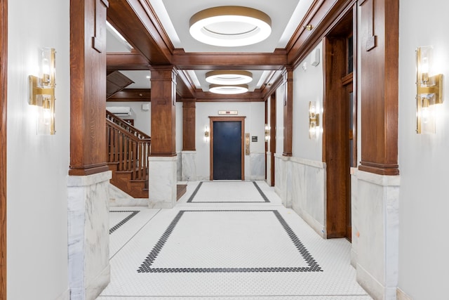 corridor with coffered ceiling, beamed ceiling, elevator, and decorative columns