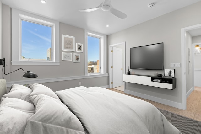 bedroom with ceiling fan, light wood-type flooring, and multiple windows