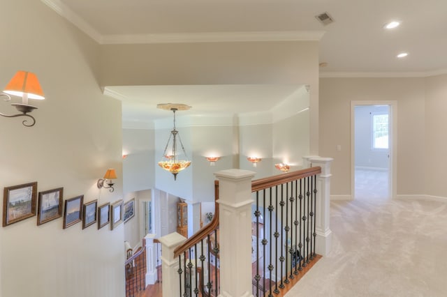 corridor featuring a notable chandelier, light carpet, and ornamental molding