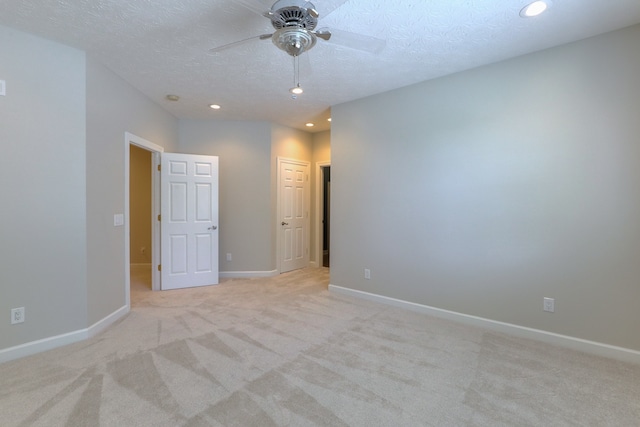 carpeted spare room featuring a textured ceiling and ceiling fan