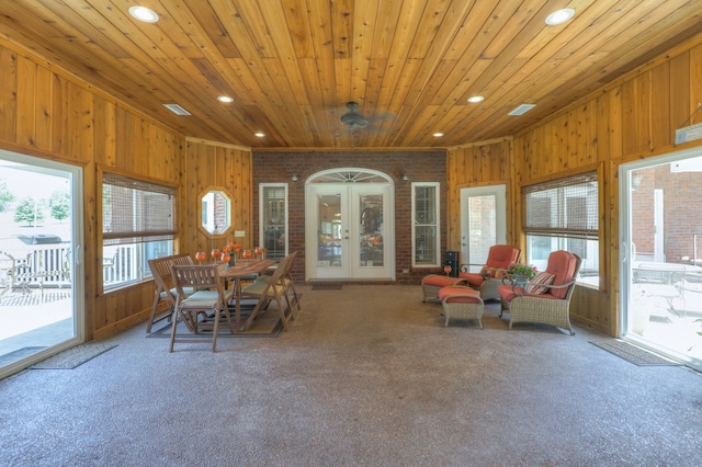 dining space with wooden walls, a wealth of natural light, french doors, and wooden ceiling