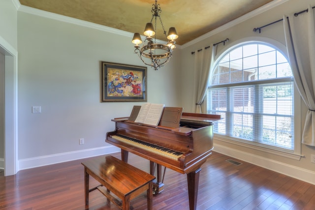 miscellaneous room with an inviting chandelier, dark wood-type flooring, and ornamental molding