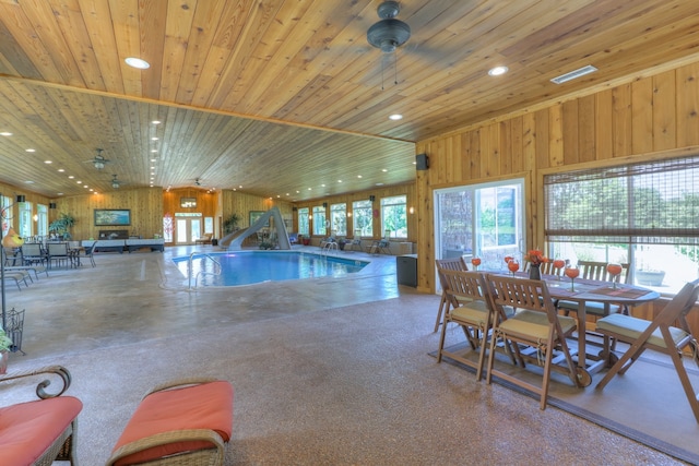 view of swimming pool featuring ceiling fan and a water slide