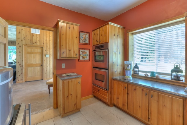 kitchen featuring stainless steel double oven and light tile floors