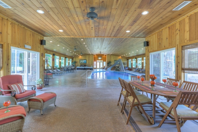 dining room featuring wood ceiling, plenty of natural light, and wood walls