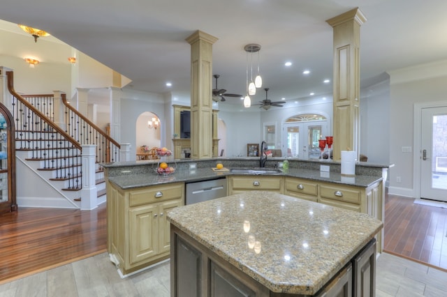 kitchen with a center island, dark stone counters, and ornate columns