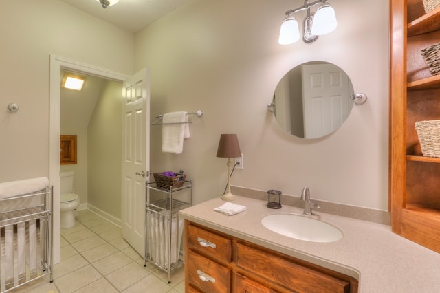 bathroom featuring vanity, tile flooring, and toilet