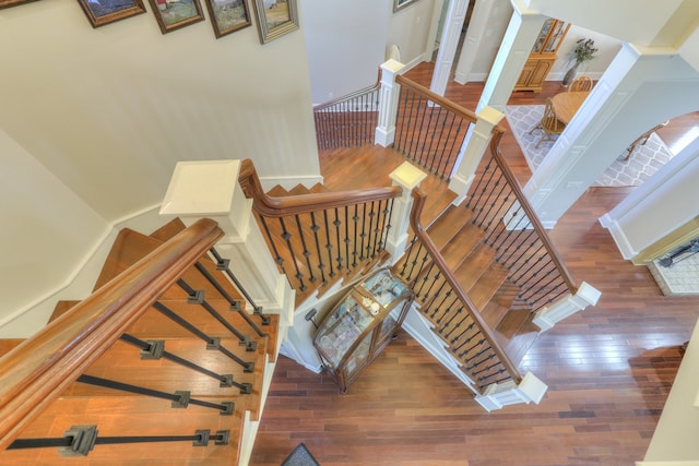 stairway with a high ceiling and dark hardwood / wood-style flooring