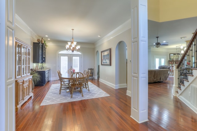 dining space featuring a wealth of natural light, dark hardwood / wood-style flooring, and ceiling fan with notable chandelier