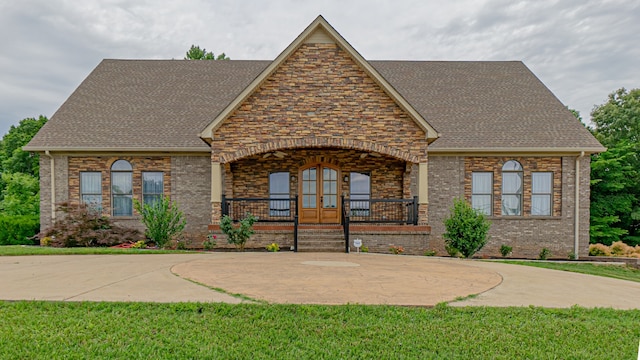 view of front of house with covered porch and a front lawn