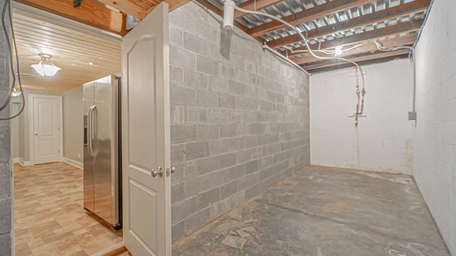 basement with stainless steel fridge with ice dispenser