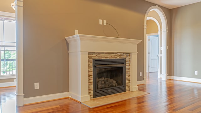 unfurnished living room featuring a tiled fireplace and light hardwood / wood-style floors