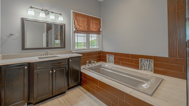 bathroom featuring vanity, tile flooring, and tiled tub