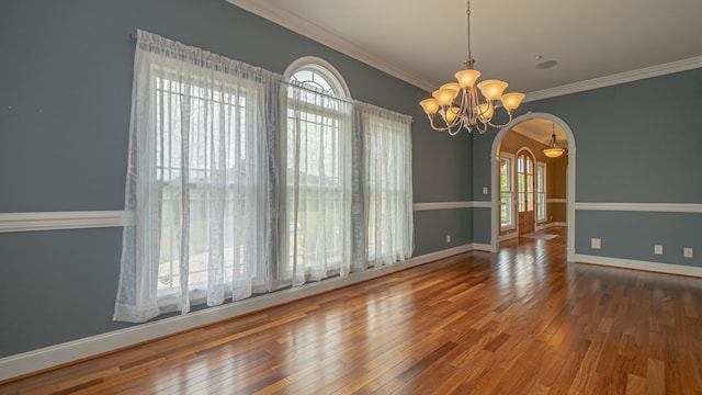 spare room featuring dark hardwood / wood-style flooring, a notable chandelier, and a wealth of natural light