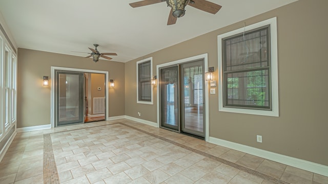 unfurnished room with ceiling fan and light tile flooring