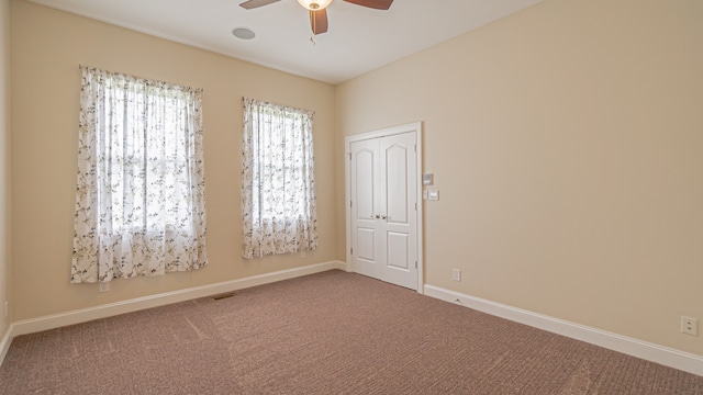 carpeted empty room featuring ceiling fan