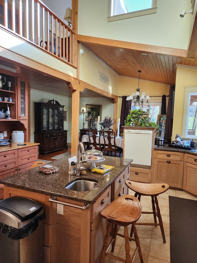 kitchen with a kitchen breakfast bar, sink, dark stone countertops, a chandelier, and wooden ceiling