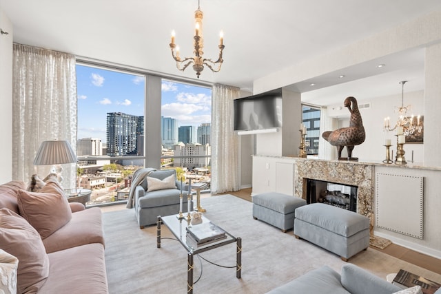 living room featuring floor to ceiling windows, a notable chandelier, a wealth of natural light, and a fireplace