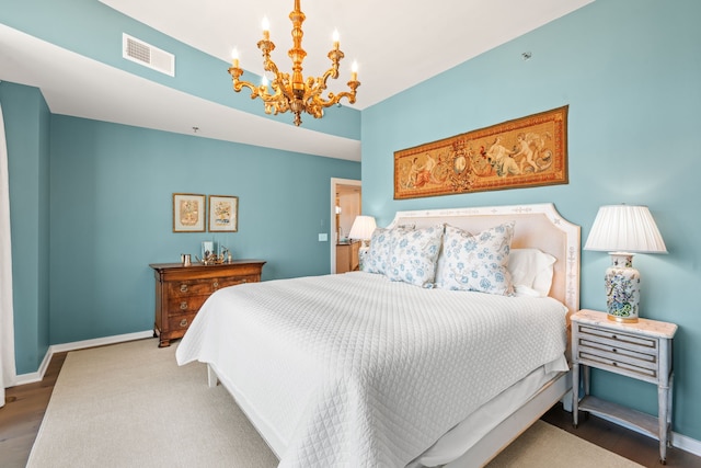 bedroom with a notable chandelier and dark hardwood / wood-style floors