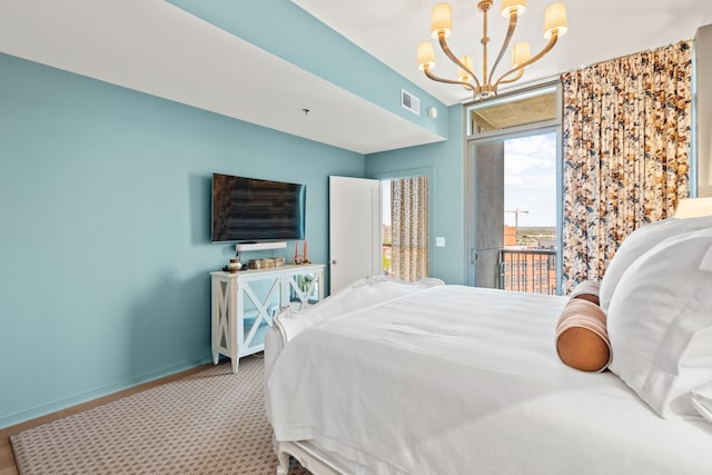 bedroom with an inviting chandelier and access to outside